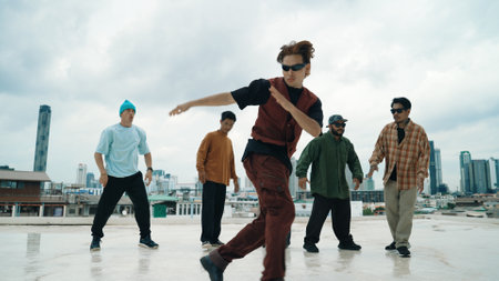 Professional break dance team practice B-boy dance while multicultural friends at rooftop. Young modern dancing group doing hip hop movement. Style,fashion,action. Outdoor sport 2024. Hiphop.の写真素材