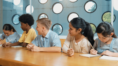 Smart boy listening teacher explain while lecturing and think about idea. Diverse student study or...