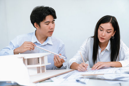 Portrait of cooperative engineer team working together to measure house model by using ruler and architectural equipment. Creative business design and teamwork concept. Immaculate..の写真素材