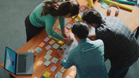 Top view of skilled designer explain and brainstorming idea for logo design and writing concept. Aerial view of business people discuss and talking while using sticky notes sharing idea. Symposium.の写真素材