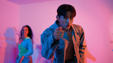 Attractive asian dancer with casual cloth dancing and looking at friend cheering him. Caucasian man and hispanic hipster perform street dancing while turn around and looking at happy team. Regalement.の写真素材