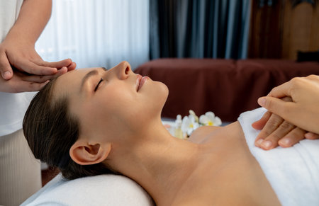 Caucasian woman enjoying relaxing anti-stress head massage and pampering facial beauty skin recreation leisure in dayspa modern light ambient at luxury resort or hotel spa salon. Quiescentの写真素材