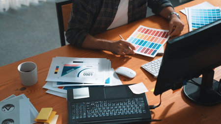 Close up of smart business man hand choosing color palettes while sitting at meeting table with note. Aerial view of interior designer design and select color theme by using color palettes. Symposium.の写真素材