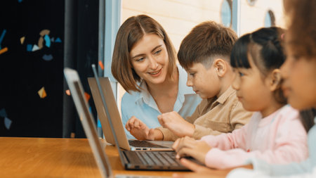 Smart teacher teaching and looking student using laptop at classroom. Professional instructor explained about programing engineering code or prompt while studying and learning program. Erudition.の写真素材
