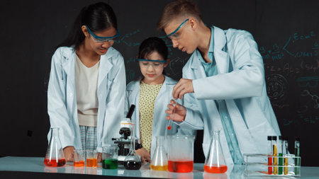 Smart girl pour colored solution in to beaker while diverse student excited about doing experiment....