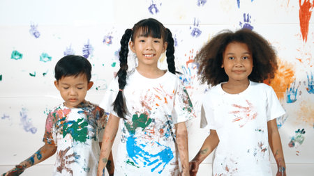 Diverse students put hands up together show colorful stained hands. Group of multicultural learner...