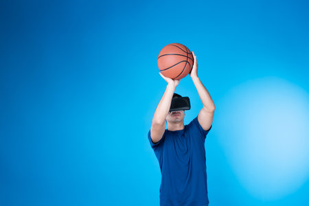 Smart basketball gaming player wearing VR glasses bouncing pose isolated blue background screen connecting digital futuristic technology virtual reality at metaverse world playing court. Contrivance.の写真素材
