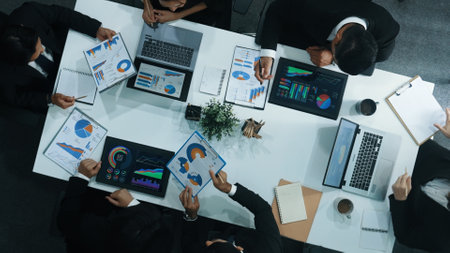 Top down aerial view of business people discussing about financial strategy on table with document...
