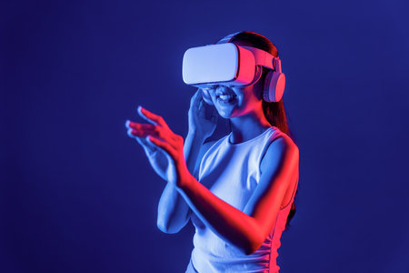 Smart female standing with surrounded by cyberpunk neon light wear VR headset connecting metaverse, futuristic cyberspace community technology. Woman using hand touching virtual object. Hallucination.の写真素材