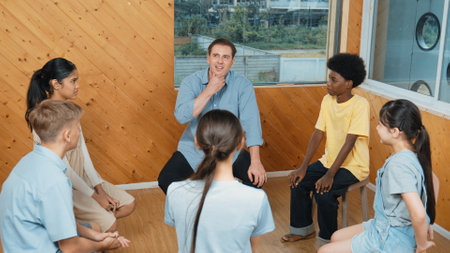 Smart girl raising hand to ask question during doing group therapy. High school student put hand up...