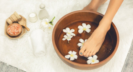 Panorama top view woman indulges in blissful foot massage at luxurious spa salon while masseur give reflexology therapy in gentle day light ambiance resort or hotel foot spa. Quiescentの写真素材