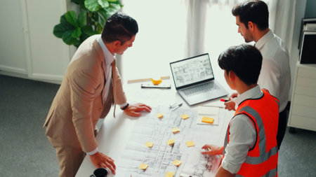 Top view of professional architect engineer team inspect house model while manager holding blueprint and asking about building construction. Group of diverse engineer working together. Alimentation.の写真素材