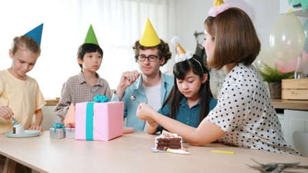 Caucasian mother cutting cake while family congratulate in girls birthday. Diverse family celebrate daughter important day while waiting for eating dessert and food while smiling together. Pedagogy.の写真素材