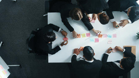 Top down ariel view of professional business team use colorful sticky notes brainstorming idea at meeting room. Diverse group share financial plan or project and point at whiteboard. Directorate.の写真素材