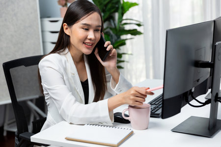 Working young Asian businesswoman calling to customer to present marketing online strategy advertisements analysis service to analyze on social website for planning channel sales target. Stratagem.の写真素材