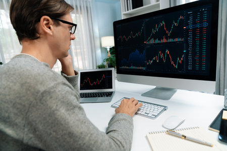 Business trader using computer and laptop to search highest profit value of dynamic increased stock...