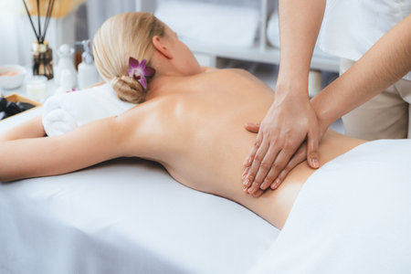 Caucasian woman customer enjoying relaxing anti-stress spa massage and pampering with beauty skin recreation leisure in day light ambient salon spa at luxury resort or hotel. Quiescentの写真素材