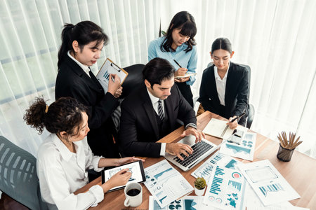 Diverse group of business analyst team analyzing financial data report paper on office table. Chart...