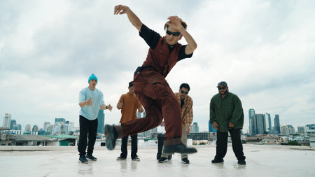 Professional asian street dancer practice B boy dance while multicultural friends at roof top. Young modern dancing group doing hip hop movement. Style,fashion,action. Outdoor sport 2024. Hiphop.の写真素材