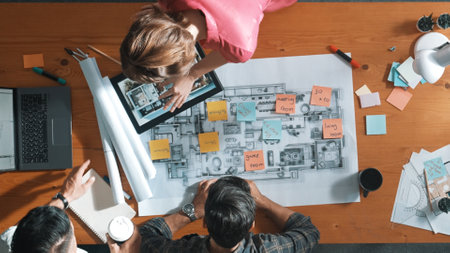 Top view of engineer working together to design building construction while standing at meeting table with blueprint and notes. Top view of interior designer choosing color from palettes. Symposium.の写真素材
