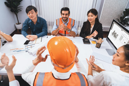 Diverse group of civil engineer and client feels excited and applauding after successful agreement on architectural project, review construction plan and building blueprint at meeting table.Prudentの写真素材