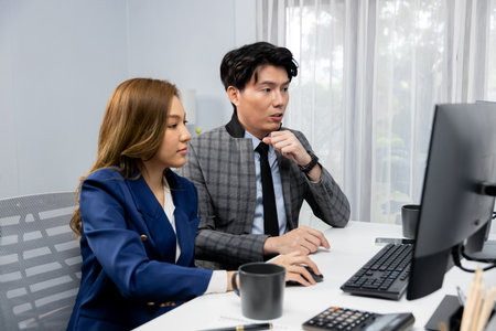 Business Asian coworkers analyzing marketing report project on two screen computer comparing value...