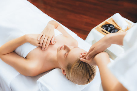 Caucasian woman enjoying relaxing anti-stress head massage and pampering facial beauty skin recreation leisure in dayspa modern light ambient at luxury resort or hotel spa salon. Quiescentの写真素材