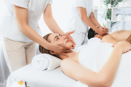 Caucasian couple enjoying relaxing anti-stress head massage and pampering facial beauty skin recreation leisure in dayspa modern light ambient at luxury resort or hotel spa salon. Quiescentの写真素材