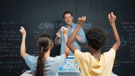 Teacher turn around and clapping hands to celebrate successful project while student raised arms...