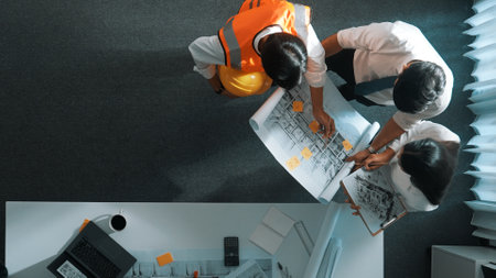 Top down view of project manager and civil engineer hold laptop while explain idea to architect....