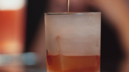 Closeup bartender pouring mixed cocktail whiskey into cool glass textured cooling ice drink making special advertisement creative focusing alcohol refresh showcase at VIP guest background. Vinosity.の写真素材