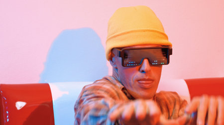 Close up of hipster with fancy glasses dancing while sitting on sofa. Happy street dancer with...