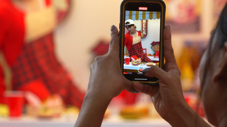Customer record video of restaurant worker dancing and holding food tray at modern bar with food....
