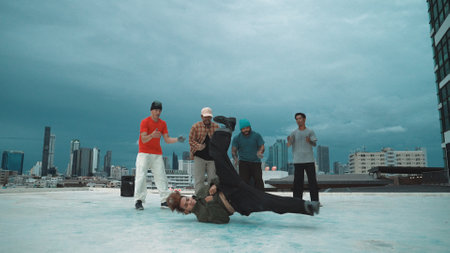 Skilled hipster perform b-boy dance surrounded by multicultural dancer at city. Attractive break...