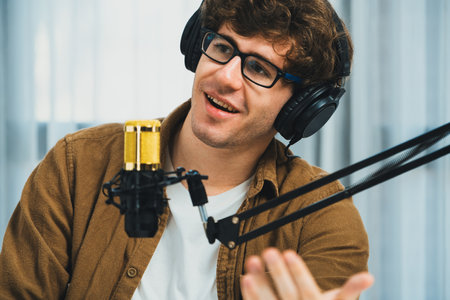 Cropped host channel on portrait of influencer using headphone talking with listeners on social media in life coaching and training marketing planning to customer target at studio office. Gusher.の写真素材
