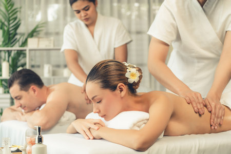 Caucasian couple customer enjoying relaxing anti-stress spa massage and pampering with beauty skin recreation leisure in day light ambient salon spa at luxury resort or hotel. Quiescentの写真素材