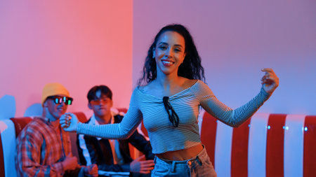 Hispanic dancer perform movement while diverse friend sitting and dancing together. Happy professional hipster moving hand while multicultural group supporting and encouraging friend. Regalement.の写真素材