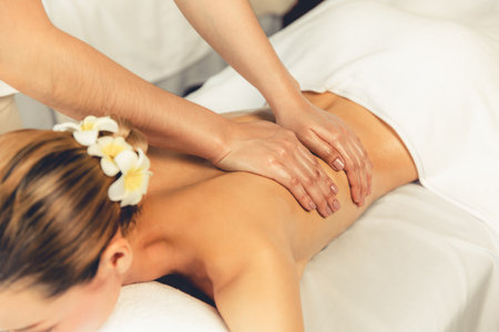 Caucasian woman customer enjoying relaxing anti-stress spa massage and pampering with beauty skin recreation leisure in day light ambient salon spa at luxury resort or hotel. Quiescentの写真素材