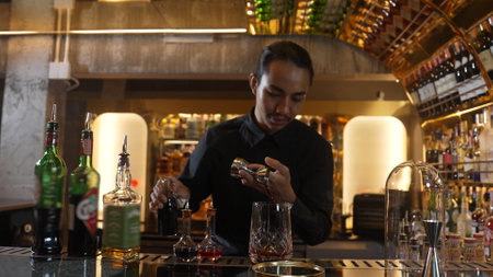 Portrait good looking Asian bartender using jigger measure liquor syrup into mixing glass...
