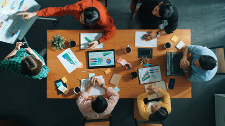 Top view of businesswoman sharing idea while stand at white board while manager asking question at table with tablet display financial graph. Attractive female leader pointing at board. Convocation.の写真素材