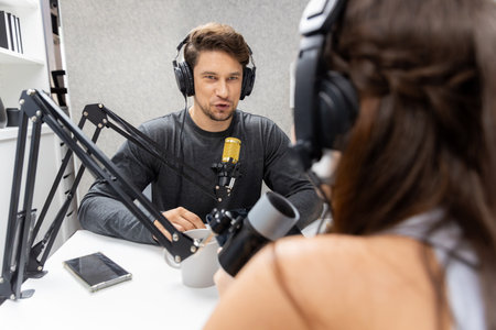 Host channel broadcaster with special guest making advice for problem in live streaming with listeners surrounded sets of live streaming on radio talking show at comfy modern workplace. Postulate.の写真素材