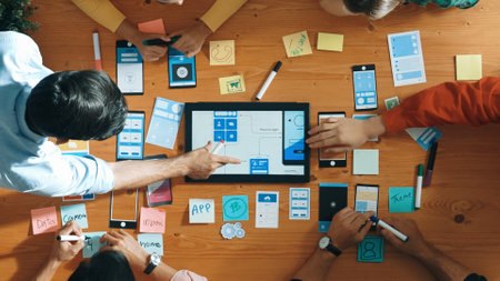 Top down view of business team writing idea on sticky note while planing for Ux Ui design for mobile...