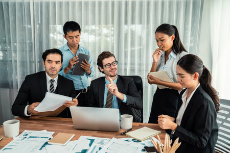 Diverse group of business analyst team analyzing financial data report paper on office table. Chart and graph dashboard by business intelligence analysis for strategic marketing planning Habilimentの写真素材