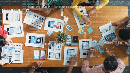 Top view of team brainstorming and looking tablet with coding program or engineering prompt. Group...