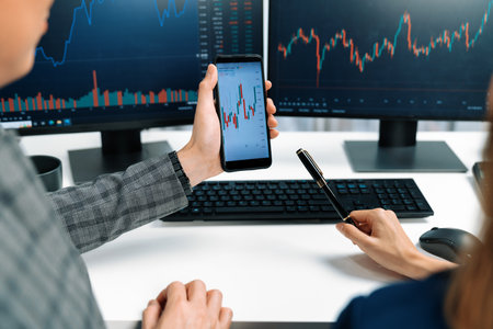 Cropped pointing hand with pen in businessman, checking with holding smartphone by woman investor...