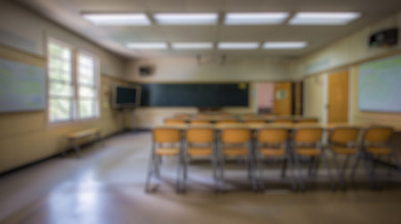 Blur background of empty classroom with table, chairs and blackboard. Educational setting photography. Academic and learning space concept. Design for educational supplies, school brochures. Spate.の写真素材