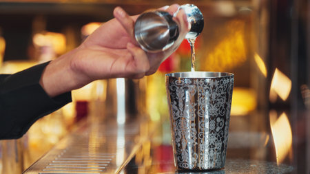 Closeup mixing hand bartender holding jigger to measure sugar salt all of ingredients into shaker preparation at bar. Special refresh drink showcasing nightlife mixology inviting warm light. Vinosity.の写真素材