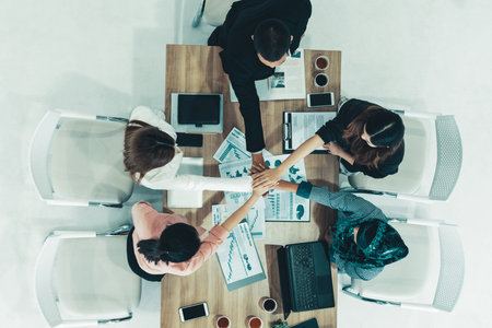 Businessmen and businesswomen joining hands in group meeting at multicultural office room showing teamwork, support and unity in business. Diversity workplace and corporate people working concept. udsの写真素材