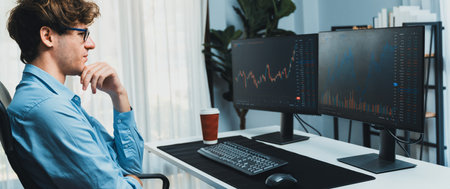 Successful smiling young investor in stock trader calling on smartphone to business partner earning high profit with dynamic financial investment screens at modern office concept on panorama. Gusher.の写真素材