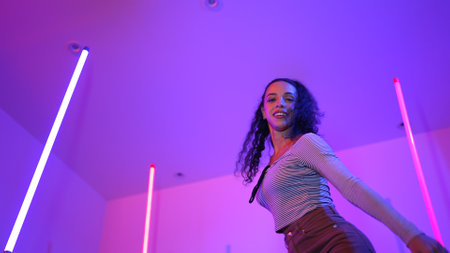Low angle camera of hispanic dancer looking at camera and dancing to city pop music. Professional...